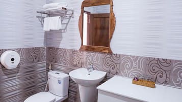 A bathroom with a toilet, sink, and vanity.