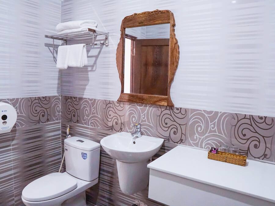 A bathroom with a toilet, sink, and vanity.