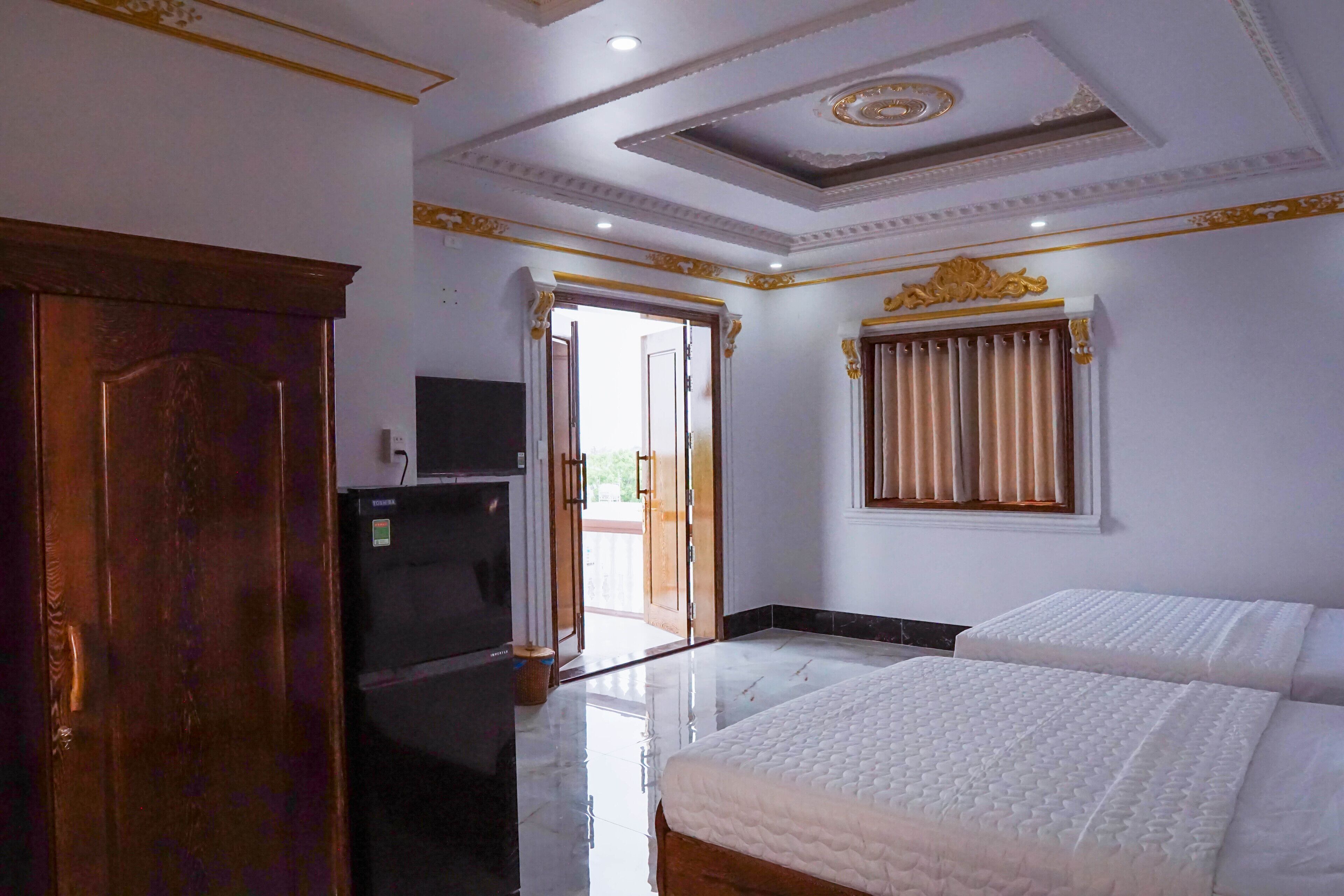 A hotel room with a bed, a television, and a wardrobe.