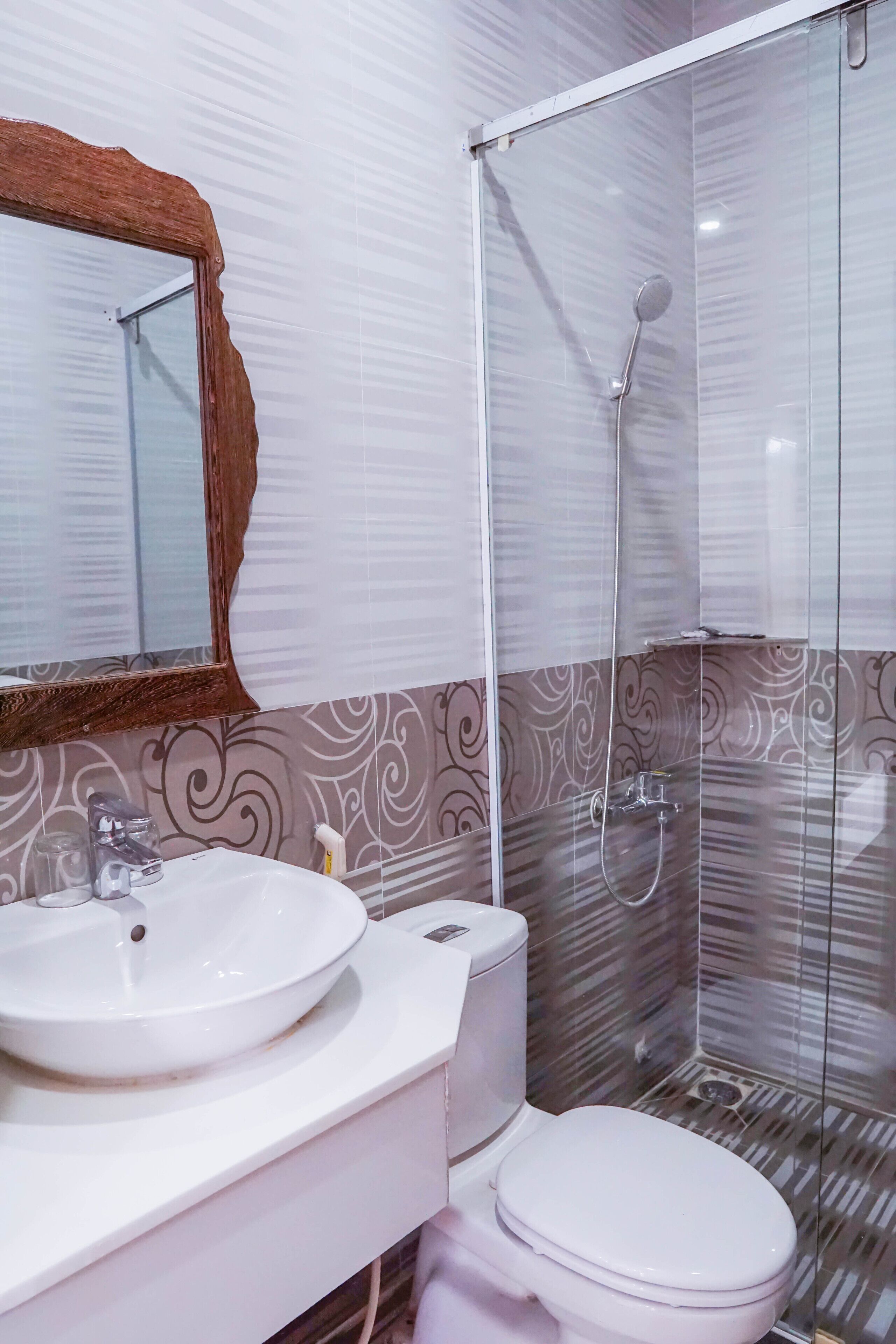 A bathroom with a white sink, a toilet, and a glass-enclosed shower.