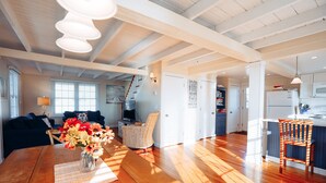 A spacious living area with a wooden dining table, a sofa, and a chair.