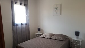 A bedroom with a bed, two bedside tables, a window with curtains, and a motivational quote on the wall. - VERY NICE GITE 4 PEOPLE CENTER VALLON PONT D'ARC (Vallon-Pont-d'Arc)