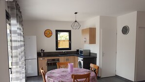 A compact kitchen with a dining area, a washing machine, and a microwave. - VERY NICE GITE 4 PEOPLE CENTER VALLON PONT D'ARC (Vallon-Pont-d'Arc)