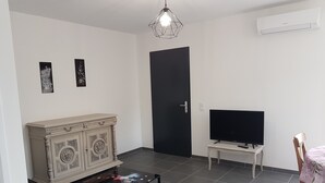 A living room with a cabinet, a television, a coffee table, and a chair. - VERY NICE GITE 4 PEOPLE CENTER VALLON PONT D'ARC (Vallon-Pont-d'Arc)