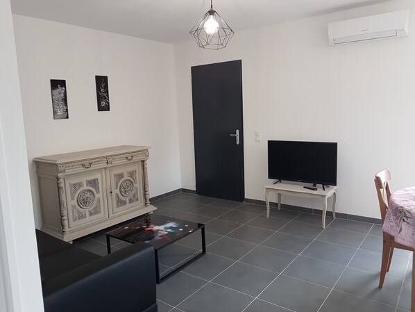 A living room with a cabinet, a television, a coffee table, and a chair. - VERY NICE GITE 4 PEOPLE CENTER VALLON PONT D'ARC (Vallon-Pont-d'Arc)