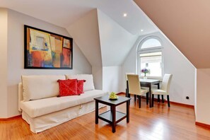 Relax in this stylish living space with a sofa, dining area, and large window offering a view of the outside.