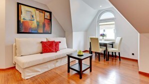 Una sala de estar moderna con un sofá blanco, una mesita y un comedor con sillas.