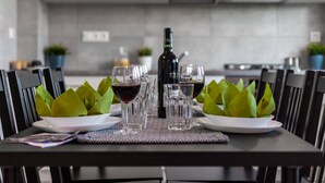 A dining table set with plates, glasses, and a bottle of wine, surrounded by chairs. - Bright Apartment in the Center | Balcony and 2 Bedrooms (Warszawa)