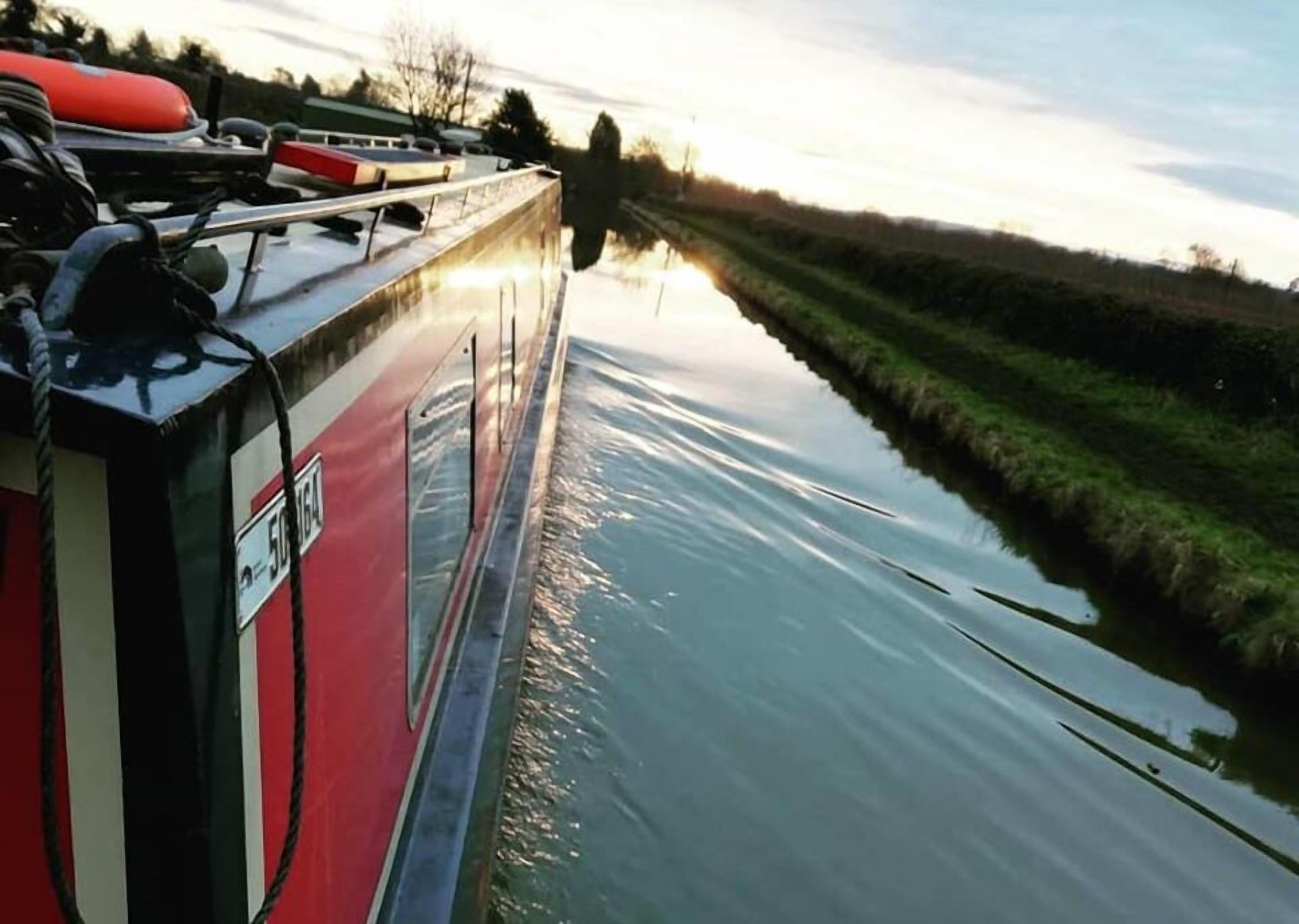 Un étroit canal, avec un bateau sur la rive gauche.