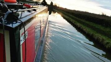 Un étroit canal, avec un bateau sur la rive gauche.