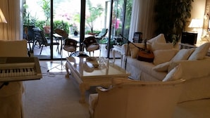 A living room with a piano, a white sofa, and a coffee table. - Lakefront Near Legoland Easy Drive to  Disney / Theme Parks  (Lake Wales)