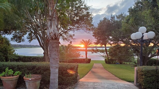 A pathway leading to a body of water with a sunset in the background. - Lakefront Near Legoland Easy Drive to  Disney / Theme Parks  (Lake Wales)
