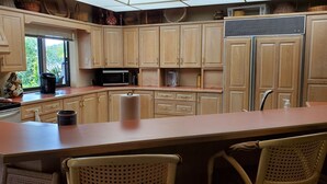 A kitchen with wooden cabinets, a microwave, a stove, and a large island with chairs. - Lakefront Near Legoland Easy Drive to  Disney / Theme Parks  (Lake Wales)
