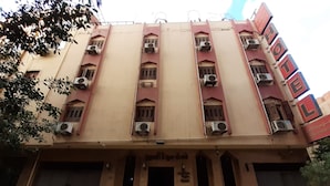 A multi-story building with a flat facade, air conditioning units, and a sign indicating it is a hotel. - Sydna All Hussain Hotel (Cairo)
