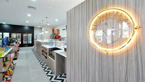 Un interior moderno con un mostrador central, vitrinas refrigeradas y un suelo estampado.