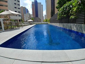 Una piscina al aire libre, tumbonas