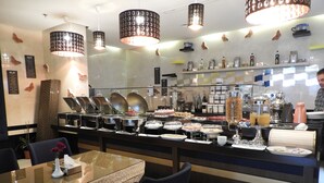 Un buffet proposant une variété de plats et un coin café.