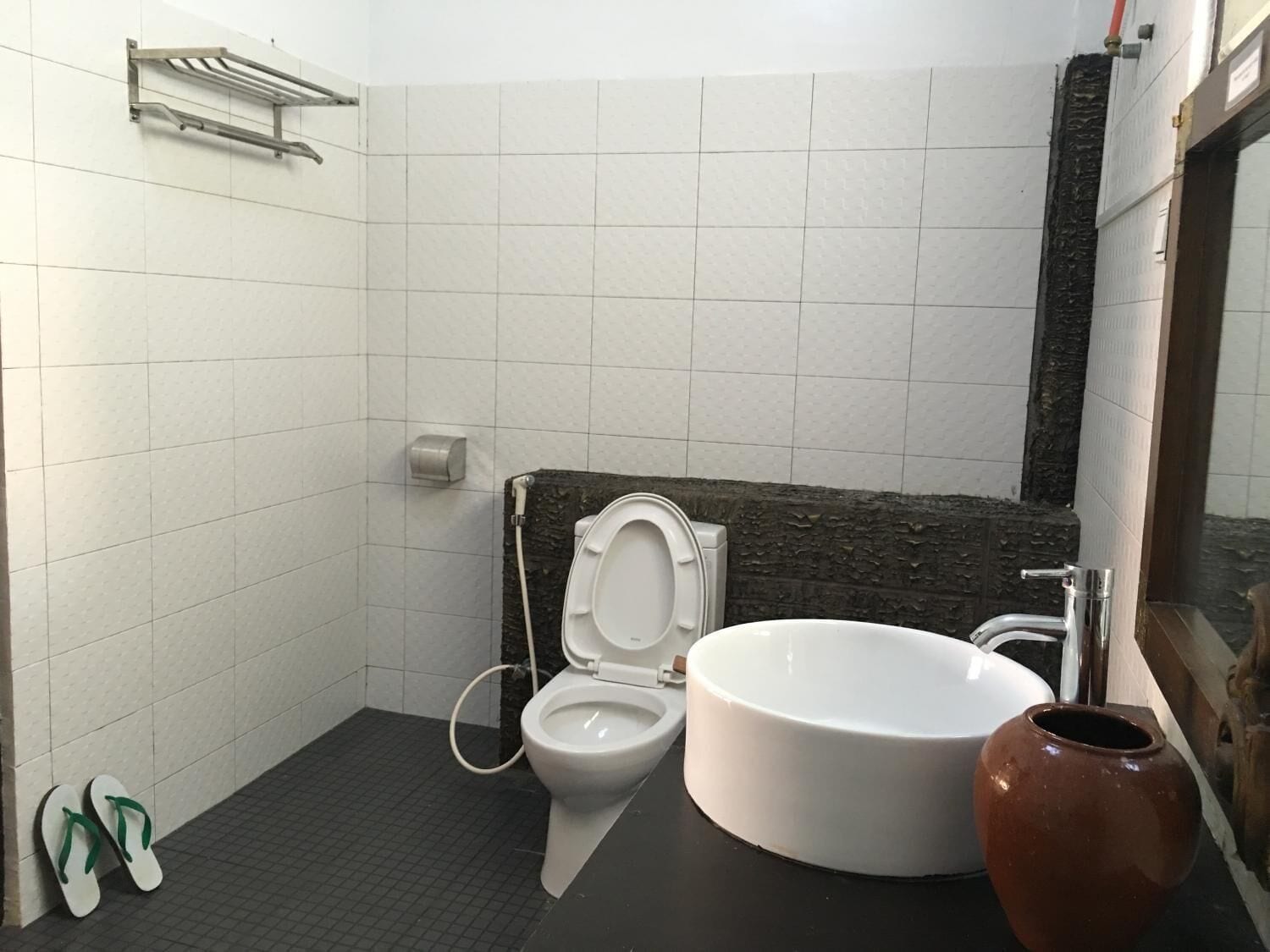 A bathroom with a toilet, sink, and a towel rack.