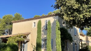 Un edificio de estilo mediterráneo, con fachada de estuco, tejas de terracota y base de piedra.
