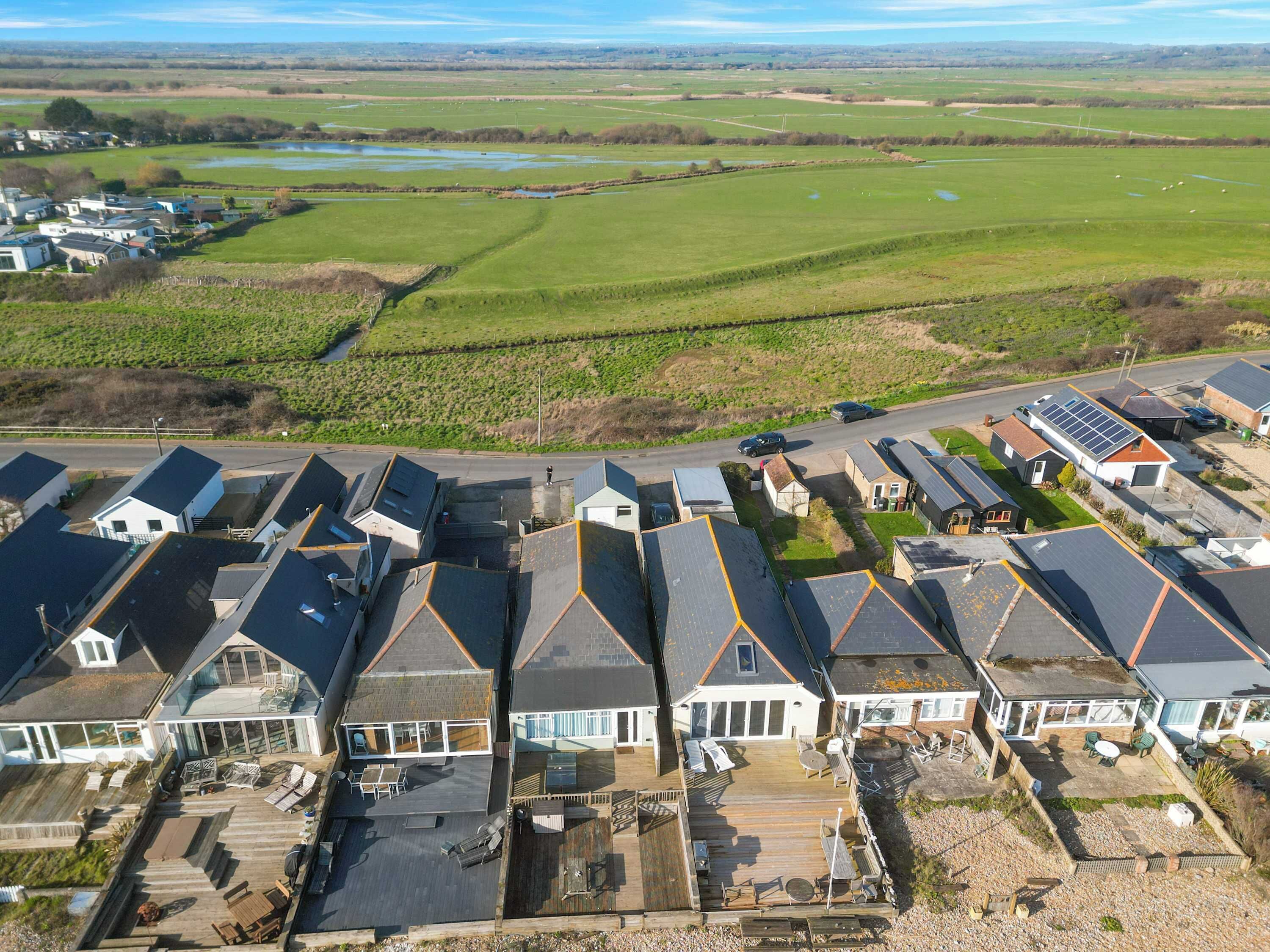 Un quartier résidentiel où les maisons sont dotées de toits à pignon et d’une terrasse en bois.