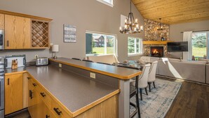 Una cocina moderna con una isla grande, armarios de madera y una chimenea de piedra.