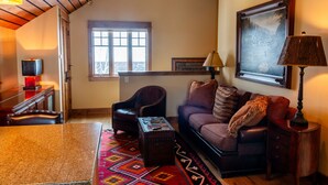 A cozy living room with a fireplace, a comfortable sofa, a coffee table, and a dining area with a table and chairs.