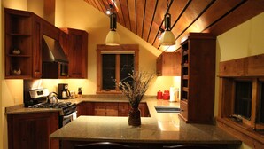 A kitchen with wooden cabinets, a granite countertop, a stove, and a window above the sink.