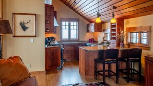 A spacious kitchen with wooden cabinets, a central island, and pendant lighting.