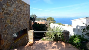 A stone building with a view of the sea and distant landscape.