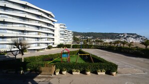 A modern hotel with a curved facade, a playground, and a parking lot. - ROCAMAURA I A 1-2 (Estartit)