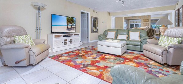 A living room with a television, sofas, a coffee table, and a patterned rug. - Luxury ground floor apartment in exclusive Ponce inlet (Ponce Inlet)