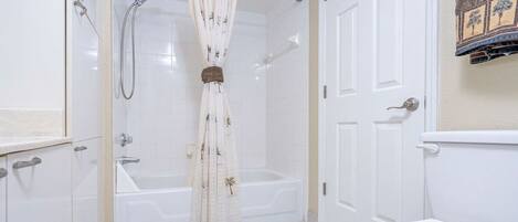 A bathroom with a bathtub, a shower, and a toilet.