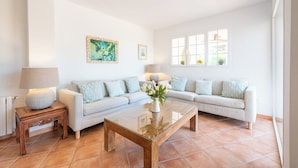 A living room with a sofa set, a coffee table, a lamp, and artwork on the wall. - Beautiful beachfront private villa with swimming pool in Cala d'Or (Cala d'Or)