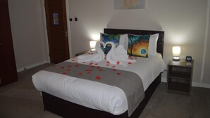 A neatly made bed with white linens, a headboard, and decorative pillows. - Jewel Guest House (Aberdeen)