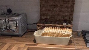 A kitchen with white cabinets, a wooden countertop, and a toaster. - Jewel Guest House (Aberdeen)