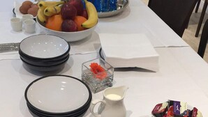 A table set with plates, bowls, a pitcher, and various food items, indicating a meal setup. - Jewel Guest House (Aberdeen)