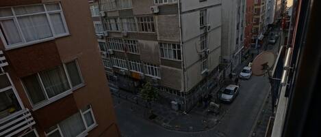 A multi-story building with a corner entrance, a street view, and a satellite dish on the side.
