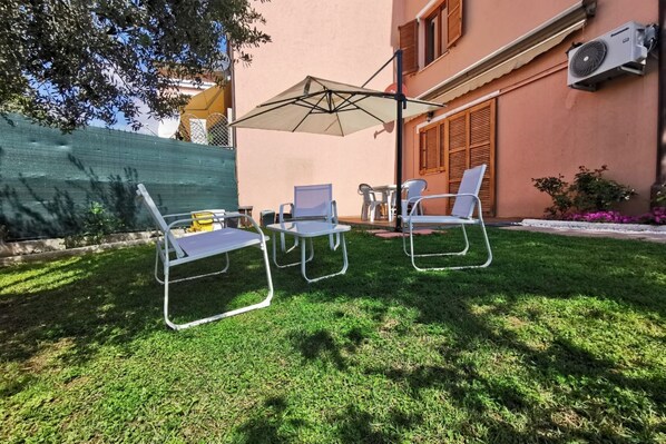 A patio with outdoor furniture, a table, and a chair.
