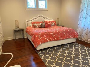 A bedroom with a bed, nightstands, a window, and a patterned rug. - Stunning 5 Bedroom Home, Short Walk to Beach, Includes 2 Golf Carts, 809 Bonito Road 809 Bonito Drive (Fripp Island)