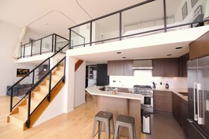 A modern kitchen with a central island, a built-in oven, and a stainless steel refrigerator. - Rare luxury Downtown Vancouver loft/sleeps 8/2 bedroom + 2 bath/1500sf + parking (Vancouver)