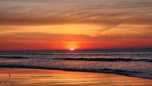 A sunset over the ocean with waves on the shore. - Ocean Views All Decks - 4BR/3BA Stilt Home in Ocean Lakes - 1006 w Golf Cart Opt (Myrtle Beach)