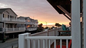 A coastal residential area with houses featuring balconies and a view of the sunset over the ocean. - Ocean Views All Decks - 4BR/3BA Stilt Home in Ocean Lakes - 1006 w Golf Cart Opt (Myrtle Beach)