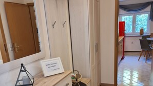 Una cocina moderna con armarios de madera, una encimera y un comedor con mesa y sillas.