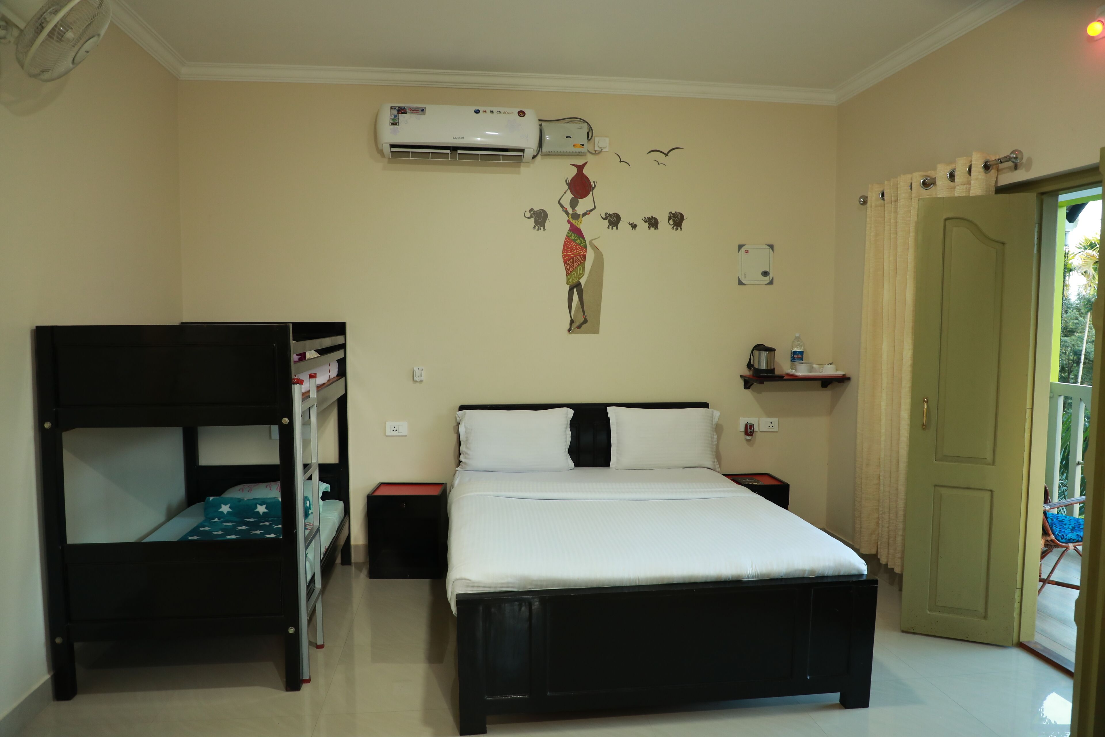 A bedroom with a bunk bed, a single bed, an air conditioner, a wall decoration, a door, and a small shelf.