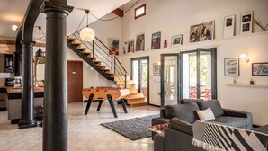 A spacious living area with a staircase, a pool table, and a cozy seating area. - Casa Nova Maison d'hotes (Coggia)