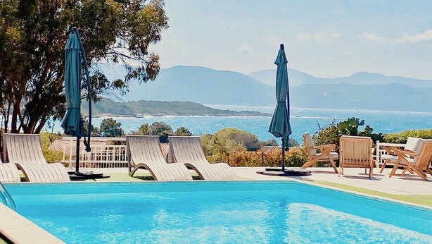 A swimming pool with lounge chairs and umbrellas, overlooking a coastal view with mountains in the distance. - Casa Nova Maison d'hotes (Coggia)