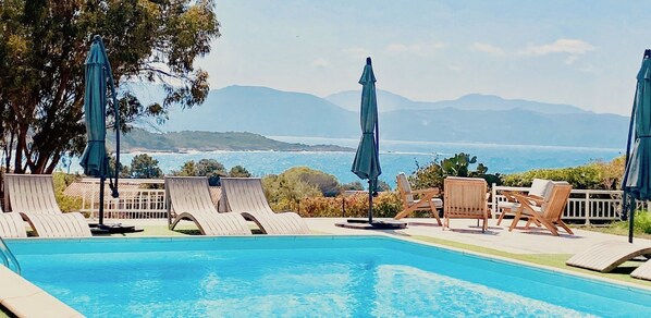 Piscine extérieure en saison, parasols, chaises longues