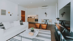 Een moderne woonkamer met een witte bank, een salontafel en een tv-meubel.