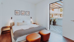 Een moderne slaapkamer met een bed, nachtkastjes en uitzicht.