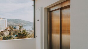 A balcony with a view of buildings and a body of water. - FLH Casa Branca Madeira 301 (Funchal)